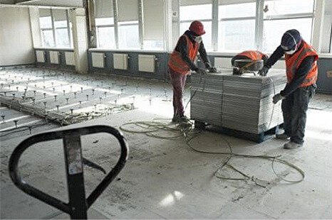 Arbeiter stapeln die Bodenplatten auf einer Palette